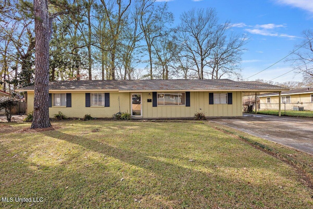 ranch-style house with a front yard and a carport