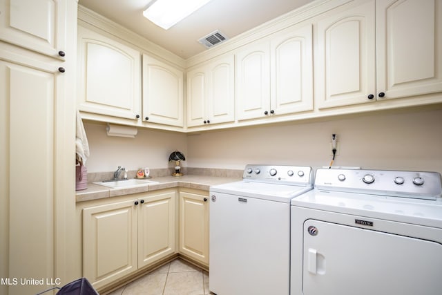 704 Tortoise Rdg, Brandon, MS 39047 - laundry room with washing machine and clothes dryer, cabinet space, and light tile patterned floors