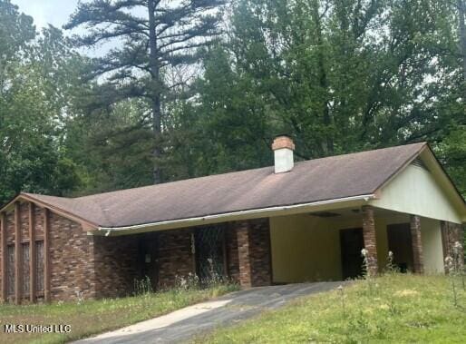 1540 Cedar Pine Dr, Jackson, MS 39212 - view of home's exterior with driveway, an attached carport, and a chimney