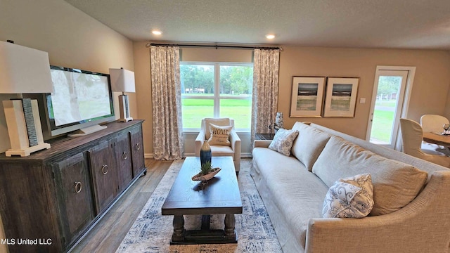 living room featuring a textured ceiling and light hardwood / wood-style floors