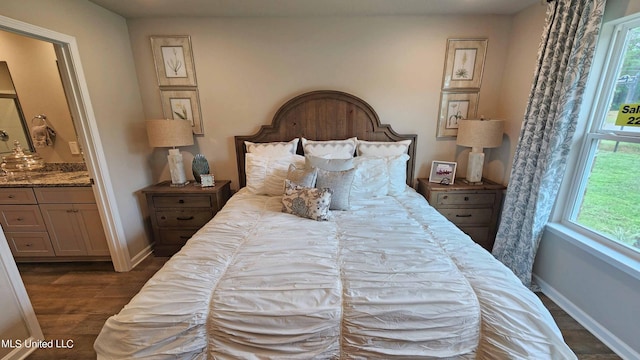 bedroom with connected bathroom and dark hardwood / wood-style flooring