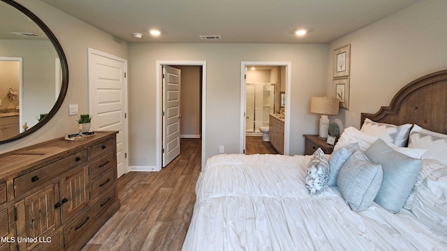 bedroom with connected bathroom and dark hardwood / wood-style floors