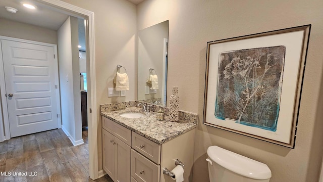 bathroom with vanity, hardwood / wood-style floors, and toilet