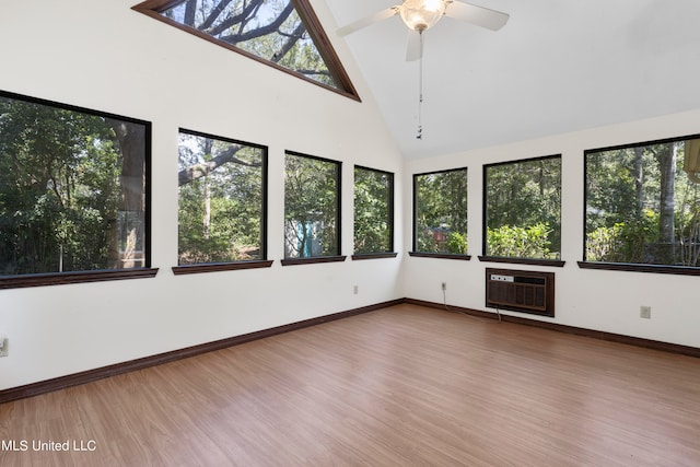 unfurnished sunroom featuring a wall mounted AC, ceiling fan, vaulted ceiling, and a wealth of natural light