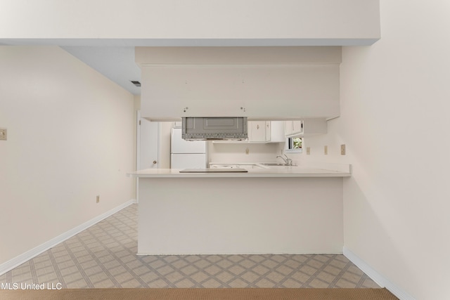 kitchen with light carpet, kitchen peninsula, sink, and white refrigerator