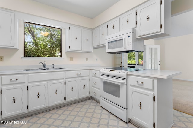 kitchen featuring light carpet, kitchen peninsula, white cabinets, sink, and white appliances