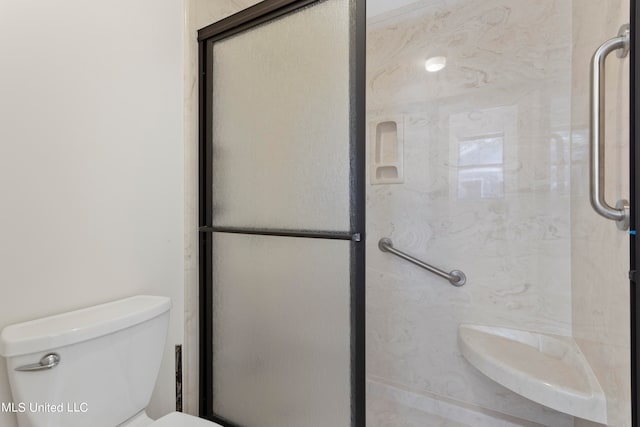 bathroom with a shower with door and toilet