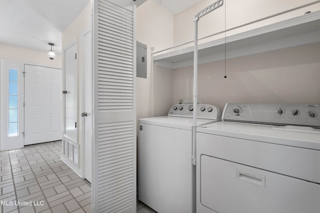 washroom featuring a textured ceiling, electric panel, and separate washer and dryer