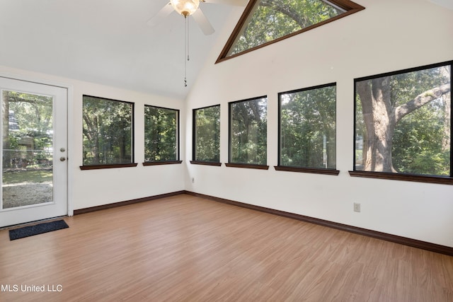 unfurnished sunroom featuring lofted ceiling, plenty of natural light, and ceiling fan