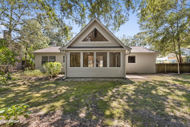 rear view of house featuring a yard