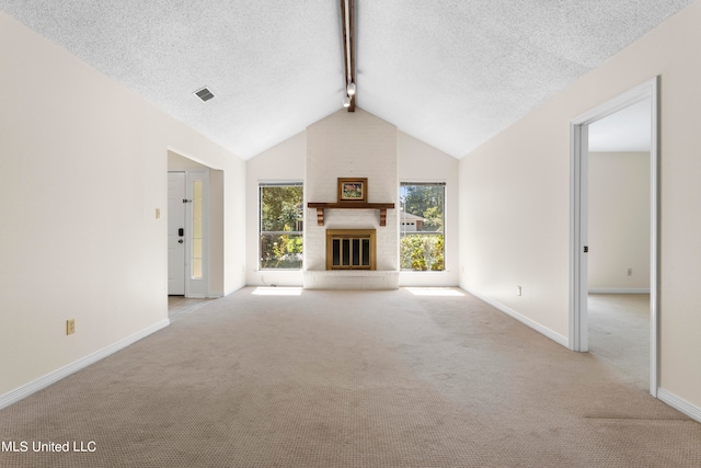 unfurnished living room featuring vaulted ceiling with beams, a textured ceiling, a brick fireplace, and light colored carpet