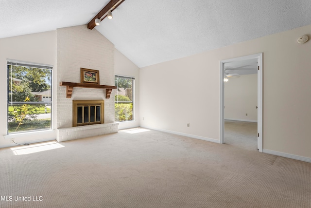 unfurnished living room with beam ceiling, ceiling fan, high vaulted ceiling, a brick fireplace, and light colored carpet