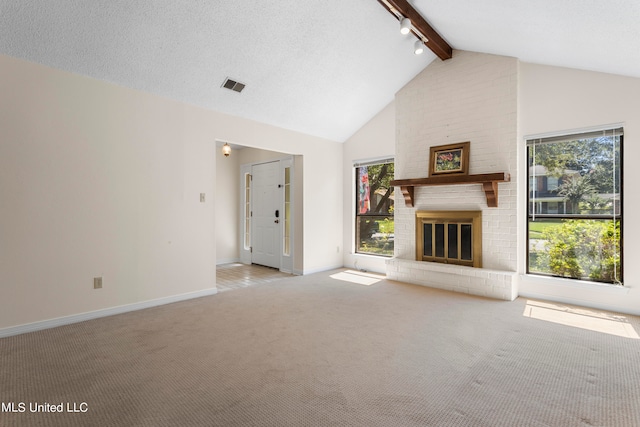 unfurnished living room with light carpet, a textured ceiling, high vaulted ceiling, beamed ceiling, and a fireplace