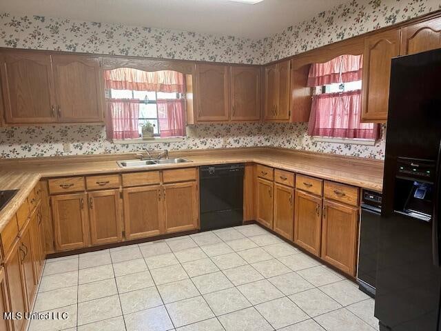 kitchen with sink, light tile patterned flooring, and black appliances