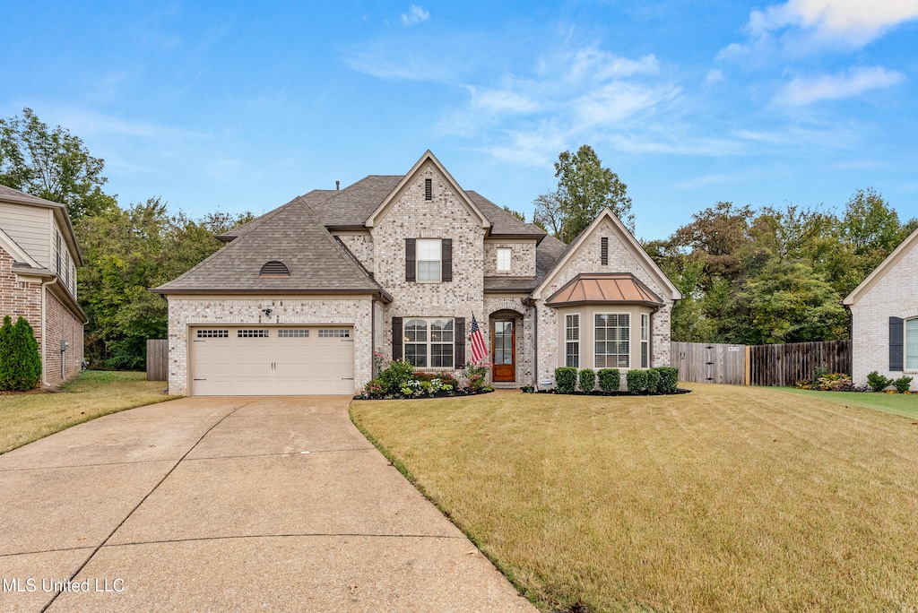 view of front of property featuring a front yard and a garage