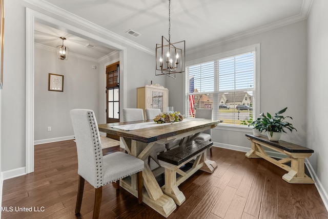 dining room with dark wood-type flooring, crown molding, and a notable chandelier