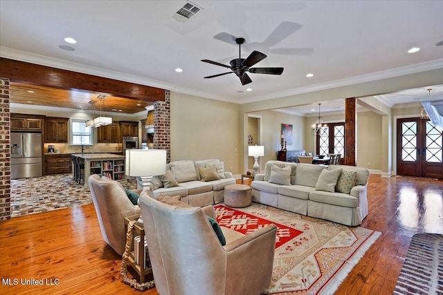 living room featuring baseboards, light wood-type flooring, ornamental molding, recessed lighting, and ceiling fan