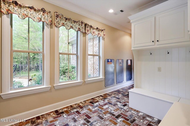 mudroom with visible vents, baseboards, crown molding, brick floor, and recessed lighting