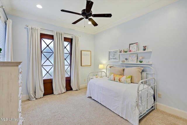 carpeted bedroom featuring baseboards, crown molding, and a ceiling fan