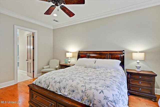 bedroom featuring visible vents, baseboards, ensuite bathroom, ornamental molding, and light wood-style floors