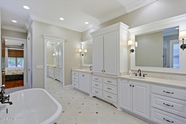 ensuite bathroom with ensuite bathroom, a freestanding bath, crown molding, vanity, and tile patterned flooring