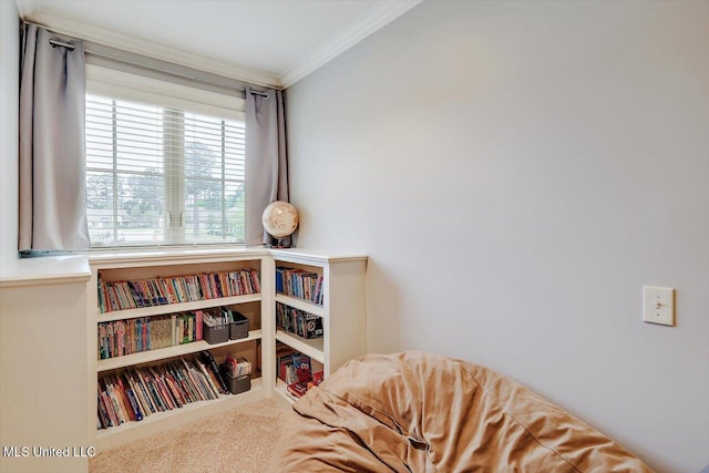 sitting room with ornamental molding and carpet