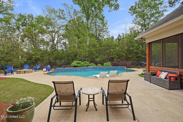 pool with an outdoor fire pit, a patio, fence, and a sunroom