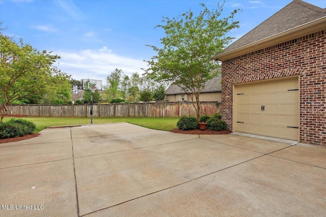 view of patio / terrace with a garage, driveway, and fence