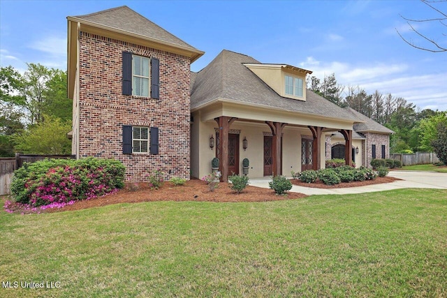 traditional home with brick siding, a front lawn, and fence