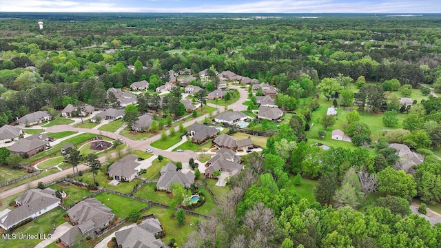 drone / aerial view with a wooded view and a residential view