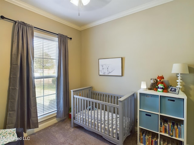 bedroom featuring a crib, ornamental molding, and carpet