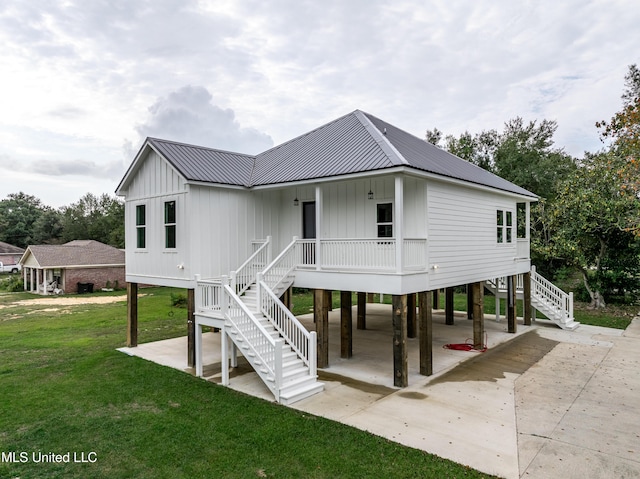 back of property with a carport and a lawn