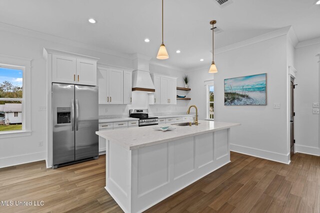 kitchen with hardwood / wood-style floors, white cabinets, hanging light fixtures, sink, and stainless steel appliances