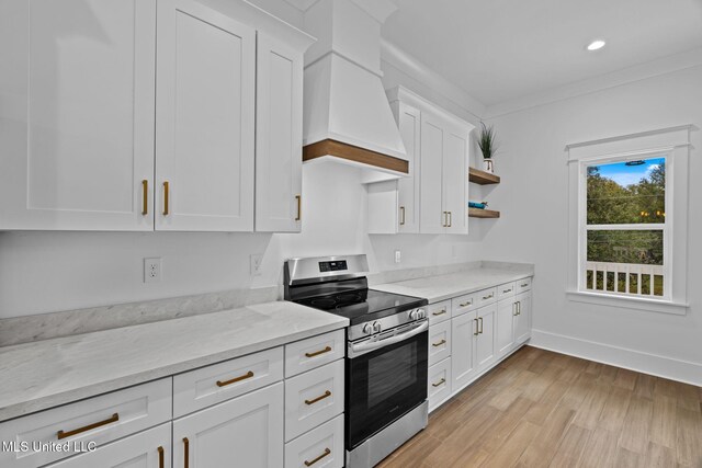 kitchen with premium range hood, white cabinetry, light wood-type flooring, and stainless steel stove