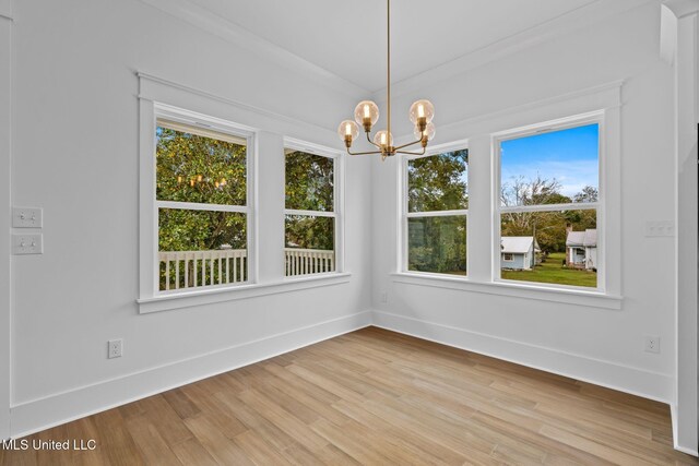 unfurnished dining area featuring a notable chandelier and hardwood / wood-style floors