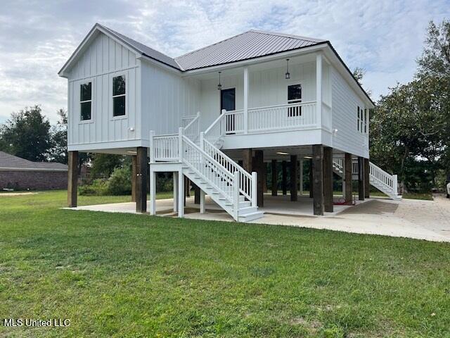 rear view of house featuring a yard, covered porch, a carport, and a patio