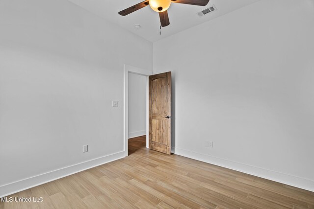 unfurnished room with a towering ceiling, light wood-type flooring, and ceiling fan