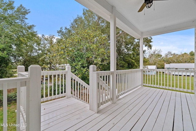 deck with a yard and ceiling fan