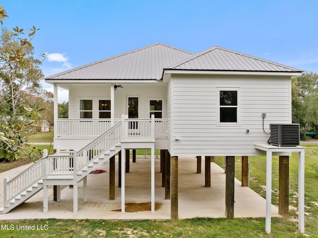 rear view of house with central air condition unit, a patio area, and a lawn