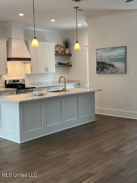 kitchen with white cabinetry, stainless steel range with gas cooktop, premium range hood, and hanging light fixtures