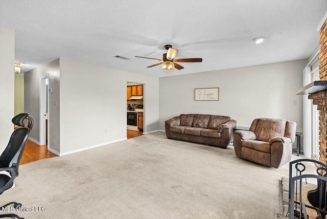 221 Highpoint Dr, Diamondhead, MS 39525 - living room with ceiling fan, a fireplace, light colored carpet, and a textured ceiling
