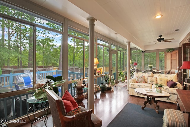 sunroom featuring ornate columns and ceiling fan