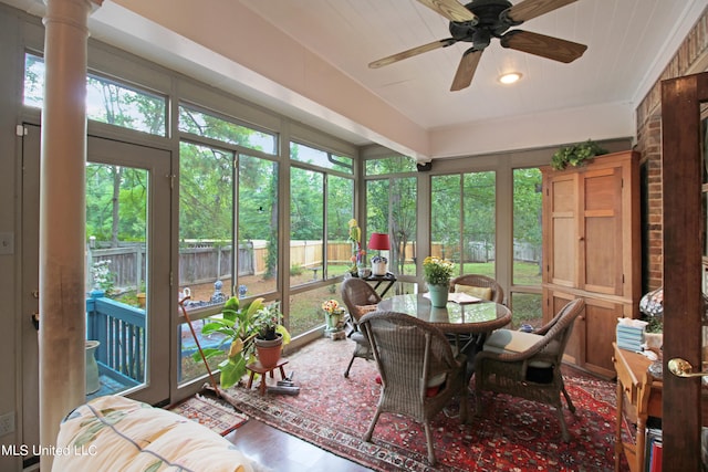 sunroom featuring ornate columns and ceiling fan