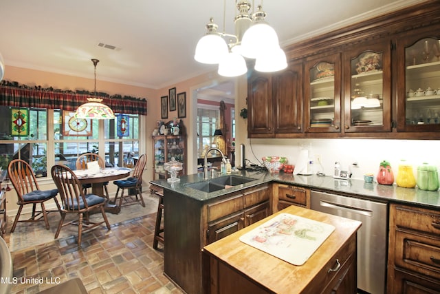 kitchen featuring stainless steel dishwasher, sink, a center island, and dark brown cabinetry