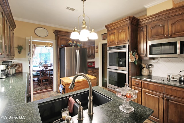 kitchen featuring tasteful backsplash, appliances with stainless steel finishes, sink, and ornamental molding