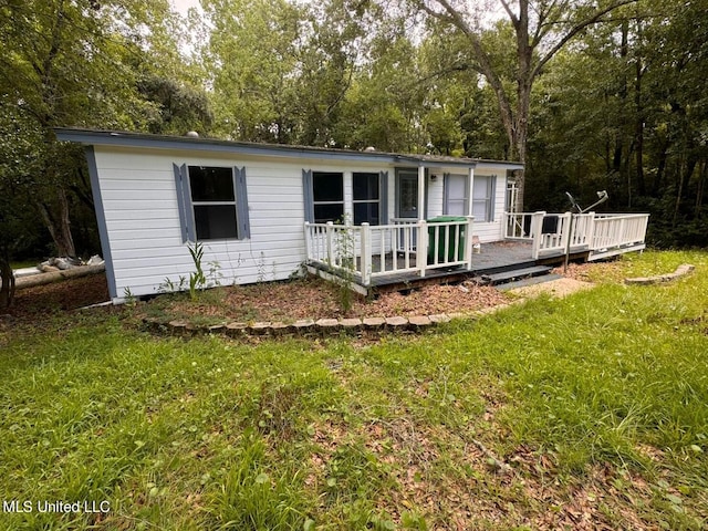 rear view of house with a yard and a deck