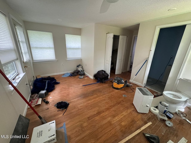 bedroom featuring ceiling fan, hardwood / wood-style flooring, and a textured ceiling