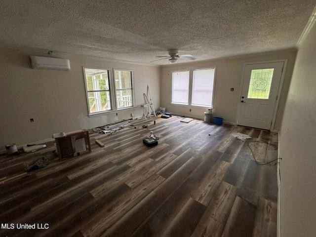 interior space with dark hardwood / wood-style floors, a wall mounted AC, a textured ceiling, and ceiling fan