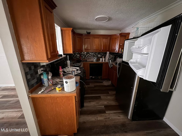 kitchen featuring dark wood-type flooring, crown molding, tasteful backsplash, and a textured ceiling