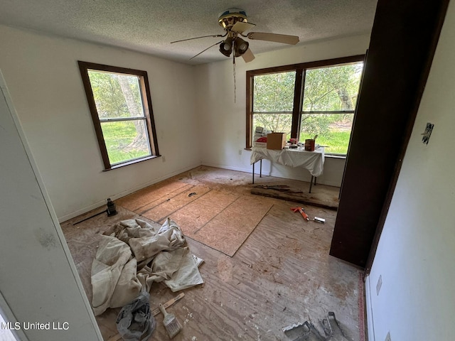 empty room featuring a textured ceiling, a healthy amount of sunlight, and ceiling fan